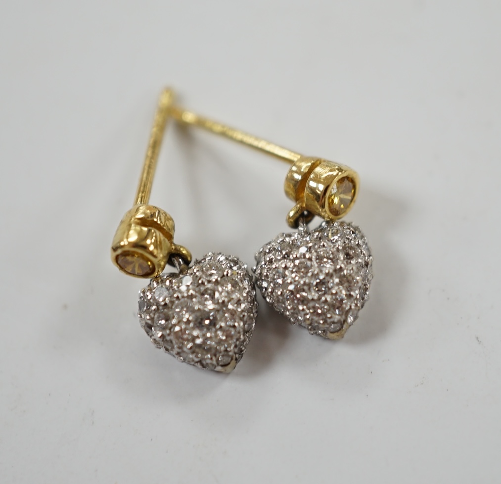 A modern pair of 750 and pave set diamond chip heart shaped ear studs, with single stone yellow diamond set bale, 9mm, gross weight 1.9 grams. Condition - good